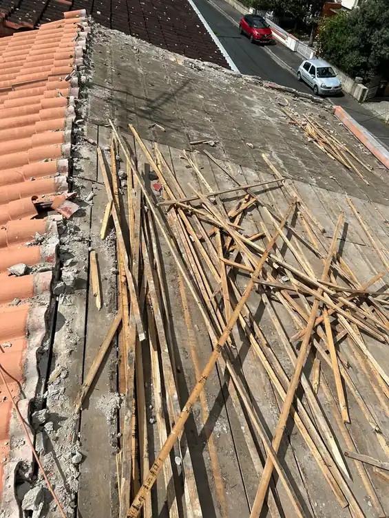 Chevrons et liteaux déposés en tas le long du faîtage
