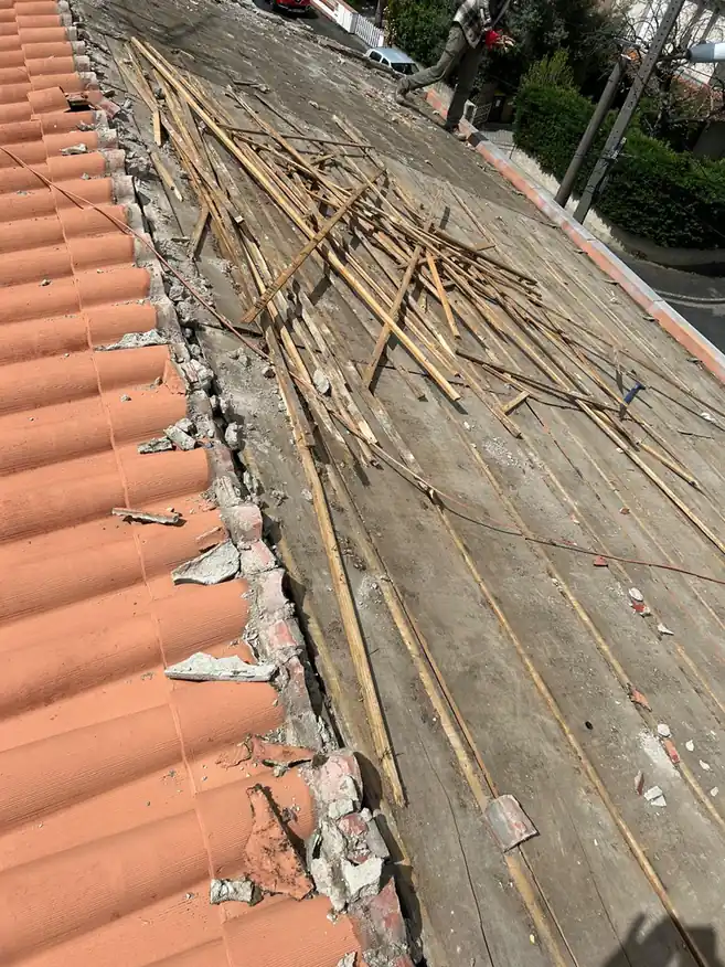 Dépose en cours : volige ancienne dégagée et débris en bord de toit