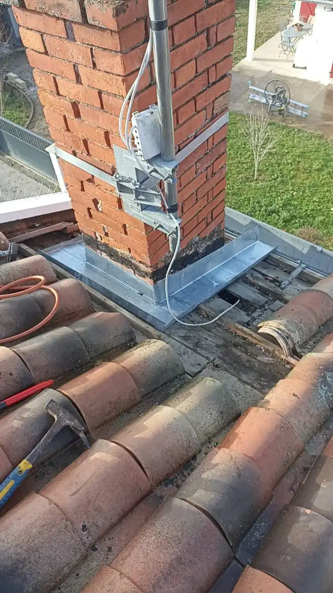Habillage en zinc d'une souche en brique et descente le long du mur