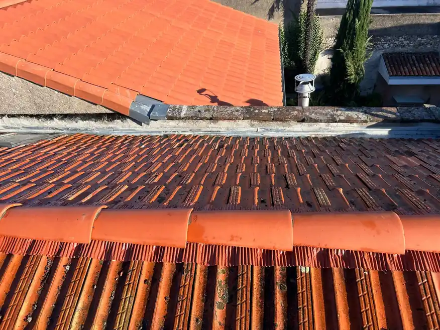Faîtage et conduit de ventilation sur une toiture reprise