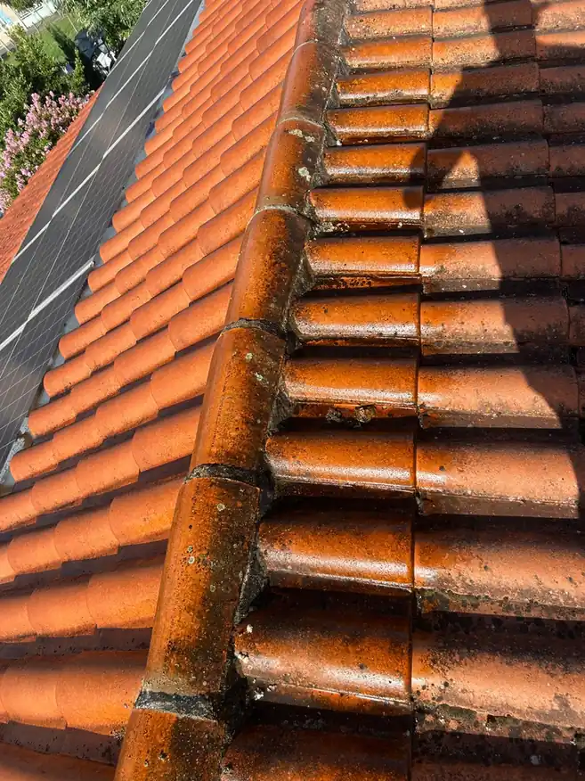 Faîtage et tuiles neuves sur un pan terminé