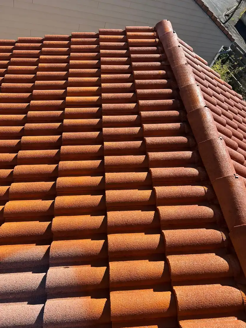 Rangs serrés de tuiles neuves sur une couverture terminée